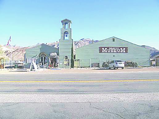 The green Beatty Museum and Historical Society building with its bell tower on Main Street